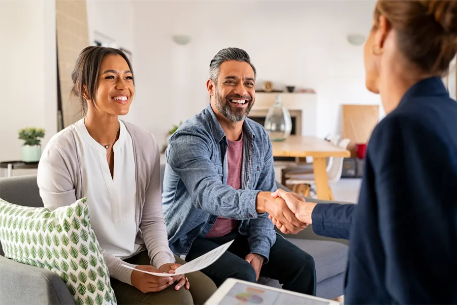 A couple shaking hands with a funeral planner